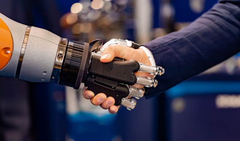 Hand of a businessman shaking hands with a Android robot. The concept of human interaction with artificial intelligence.